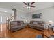 Spacious living room with hardwood floors, ceiling fan, comfortable seating, and staircase access at 101 Cambridge Way, Oxford, NC 27565