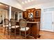 Wet bar area featuring custom wood cabinets, granite countertop, wine storage, and barstool seating at 101 Hedwig Ct, Cary, NC 27518