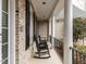 Relaxing front porch with white columns and black rocking chairs offering a cozy outdoor seating area at 101 Hedwig Ct, Cary, NC 27518