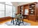 Bright home office featuring custom built-in shelving, hardwood floors, and large windows at 101 Hedwig Ct, Cary, NC 27518