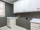 Laundry room with white cabinets, sink, countertop, and tile flooring at 101 Hedwig Ct, Cary, NC 27518