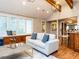 Living room featuring vaulted ceiling, exposed beams, and hardwood floors, adjacent to wet bar at 101 Hedwig Ct, Cary, NC 27518