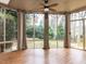 Sunroom featuring ceiling fan, wood floors, and walls of windows with views of the backyard at 101 Hedwig Ct, Cary, NC 27518