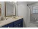 Charming bathroom with blue vanity, framed mirror, and shower with white curtain at 101 Settlecroft Ln, Holly Springs, NC 27540