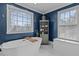 Well-lit bathroom features a standalone tub, blue accent wall, and bright windows at 101 Settlecroft Ln, Holly Springs, NC 27540