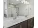 Modern bathroom with dual sinks, granite countertop, large mirror, and updated shower at 105 Hanover Ct, Clayton, NC 27527