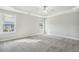 Spacious bedroom with large windows, gray carpet and ceiling fan with recessed ceiling at 105 Hanover Ct, Clayton, NC 27527