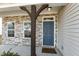 Inviting covered entry with a blue front door, supported by a decorative wooden post at 105 Hanover Ct, Clayton, NC 27527