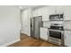Kitchen features stainless steel appliances, sleek white cabinets, and hardwood flooring at 105 Hanover Ct, Clayton, NC 27527