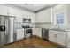 Modern kitchen features stainless steel appliances, white cabinets, and granite countertops at 105 Hanover Ct, Clayton, NC 27527