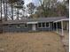 Charming single-story home featuring a gray brick facade, covered carport, and well-manicured front yard at 1128 Horseshoe Rd, Durham, NC 27703