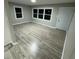 Bright living room featuring hardwood floors, large windows, and a fresh coat of paint, offering a welcoming space at 1128 Horseshoe Rd, Durham, NC 27703