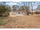 View of the backyard featuring a concrete patio surrounded by trees and lawn at 1206 Dubose St, Garner, NC 27529