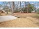 Spacious backyard with a concrete patio, surrounded by trees and mulched areas at 1206 Dubose St, Garner, NC 27529