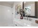 Bathroom with white tiled shower, marble countertop, and decorative mirror at 1206 Dubose St, Garner, NC 27529