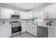 Bright kitchen features stainless steel appliances, white cabinets, and light backsplash at 1206 Dubose St, Garner, NC 27529