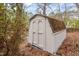 Outdoor shot of the backyard storage shed with a wooden door and weathered roof at 1206 Dubose St, Garner, NC 27529