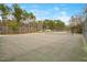 Full-sized tennis court provides an opportunity for recreation and competitive play, set against a natural backdrop at 121 Sacred Fire Rd, Louisburg, NC 27549