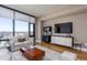 Comfortable living room featuring a large window, a modern entertainment center, and a plush white sofa at 122 N Harrington N St # 1105, Raleigh, NC 27603