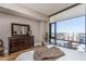 Bright bedroom with a large window showcasing city views, complemented by hardwood floors and a wooden dresser at 122 N Harrington St # 1105, Raleigh, NC 27603