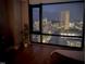 Bedroom with city views through a large window, featuring hardwood floors and a cozy setting at 122 N Harrington St # 1105, Raleigh, NC 27603