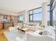 Open concept living room with a modern kitchen, large windows, and comfortable seating area at 122 N Harrington St # 1105, Raleigh, NC 27603