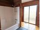 Bathroom with a shower/tub combo, wood paneled walls, and updated hardware at 1269 Manns Chapel Rd, Pittsboro, NC 27312