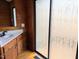 Bathroom featuring wood paneled walls, a sink with updated hardware, and a standing shower at 1269 Manns Chapel Rd, Pittsboro, NC 27312