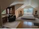 Cozy bedroom with sloped ceilings, hardwood floors, and a comfortable seating area at 1269 Manns Chapel Rd, Pittsboro, NC 27312