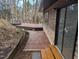Outdoor deck with a walkway, brick accents, and wood railing at 1269 Manns Chapel Rd, Pittsboro, NC 27312