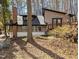 View of the home's exterior, featuring wood siding, a brick chimney, and a sloped roof at 1269 Manns Chapel Rd, Pittsboro, NC 27312