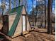 Small A-frame cabin with wood siding and green metal roof near a lake at 1269 Manns Chapel Rd, Pittsboro, NC 27312