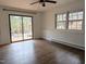 Bright room with hardwood floors, large windows, a ceiling fan, and sliding doors at 1269 Manns Chapel Rd, Pittsboro, NC 27312