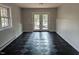 View of the room with checkerboard flooring and double doors leading to the outside at 1269 Manns Chapel Rd, Pittsboro, NC 27312