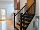 View of the staircase with wood treads and black railings, next to a brick accent wall and built-in shelves at 1269 Manns Chapel Rd, Pittsboro, NC 27312