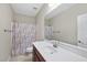 A bathroom with a wide mirror above the sink and a patterned shower curtain at 1319 Rodessa Run, Raleigh, NC 27607