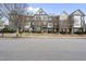Street view of brick townhomes showcasing sidewalks and well-maintained landscaping under a partly cloudy sky at 1319 Rodessa Run, Raleigh, NC 27607