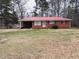 Charming red brick home with red roof and a spacious front yard surrounded by mature trees at 16 Marsh Mciver Rd, Bear Creek, NC 27207