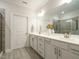 Primary bathroom with double vanities, a large mirror, and a glass enclosed walk-in shower at 177 Magenta Rose Dr, Raleigh, NC 27610