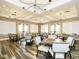 Spacious dining area with wood-look floors, stylish lighting, and multiple tables for gathering and socializing at 177 Magenta Rose Dr, Raleigh, NC 27610