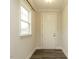 Bright entryway featuring wood flooring and a white door illuminated by natural light from the nearby window at 177 Magenta Rose Dr, Raleigh, NC 27610