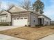 Charming single-Gathering home with stone accents, a gray exterior, and a two-car garage with an inviting curb appeal at 177 Magenta Rose Dr, Raleigh, NC 27610