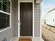 A brown front door with white trim, a 'Welcome' mat, and gray siding, offering a warm invitation at 177 Magenta Rose Dr, Raleigh, NC 27610
