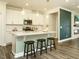 A modern kitchen with white cabinets, stainless steel appliances, and a large center island with pendant lighting at 177 Magenta Rose Dr, Raleigh, NC 27610