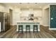 A modern kitchen with white cabinets, stainless steel appliances, and a large center island with pendant lighting at 177 Magenta Rose Dr, Raleigh, NC 27610