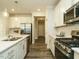 A modern kitchen with white cabinets, stainless steel appliances, and a large center island with pendant lighting at 177 Magenta Rose Dr, Raleigh, NC 27610
