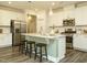 A modern kitchen with white cabinets, stainless steel appliances, and a large center island with pendant lighting at 177 Magenta Rose Dr, Raleigh, NC 27610