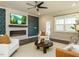 Stylish living room featuring a fireplace, designer wallpaper, modern furniture, and a ceiling fan at 177 Magenta Rose Dr, Raleigh, NC 27610