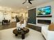 An open-concept living space and kitchen with modern furniture, a cozy fireplace, and a dining area at 177 Magenta Rose Dr, Raleigh, NC 27610