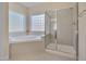 Neutral bathroom features a glass shower, a soaking tub and two windows at 2006 Mill Gate Ln, Cary, NC 27519